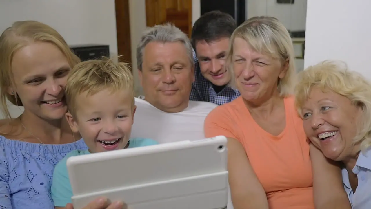 Family with child watching interesting video on pad