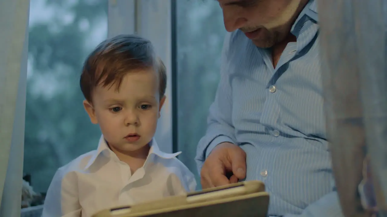 Father and son spending leisure time with touch pad