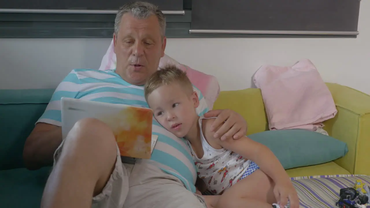 Grandfather and grandchild with laptop at home