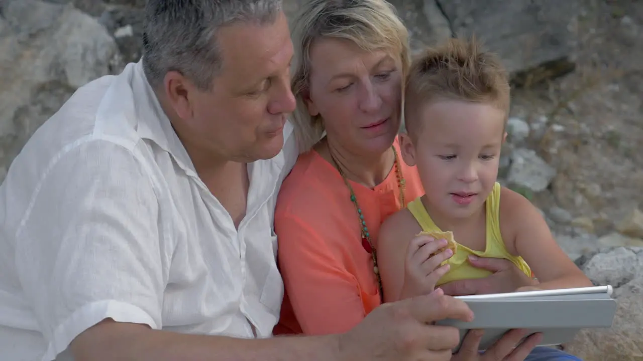 Child enjoying pad game with grandparents