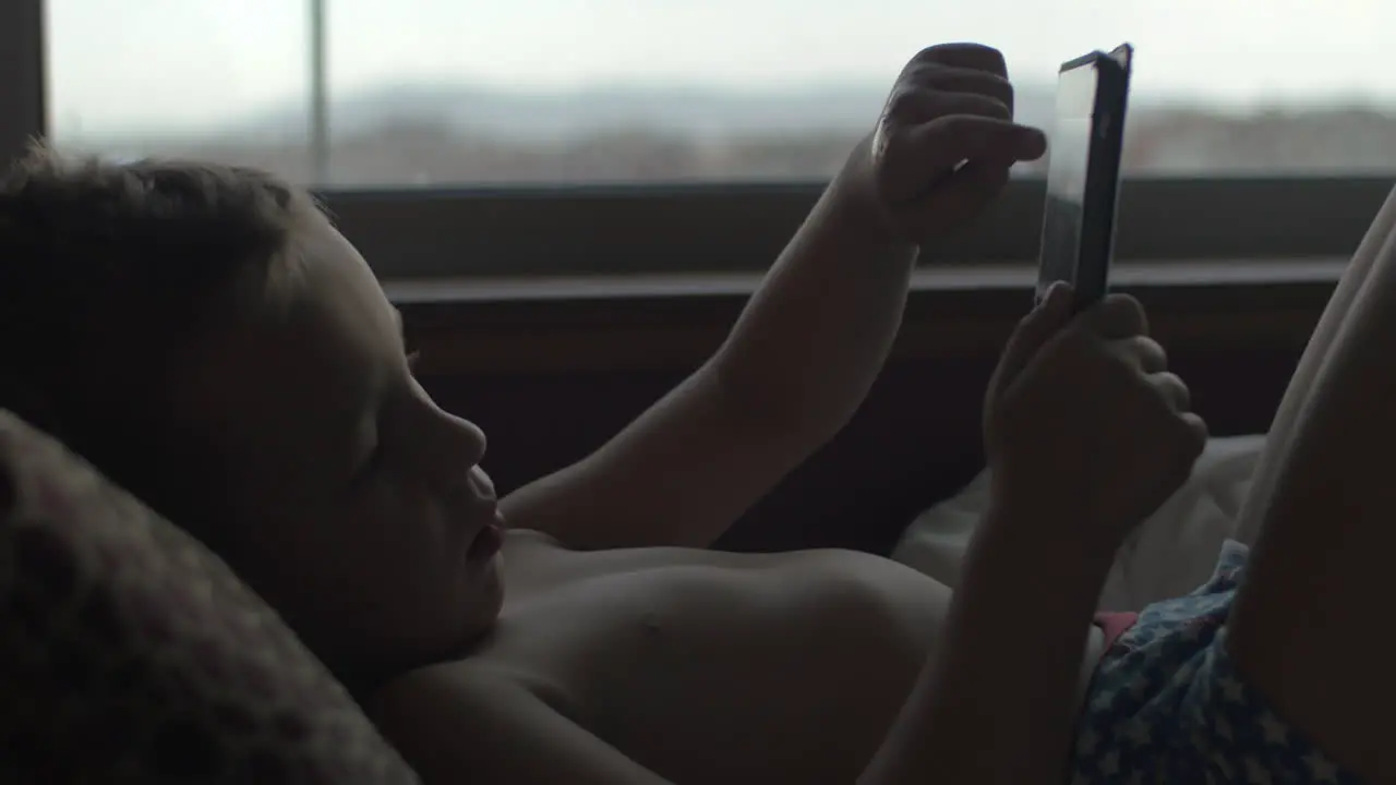 Child using digital tablet in bed