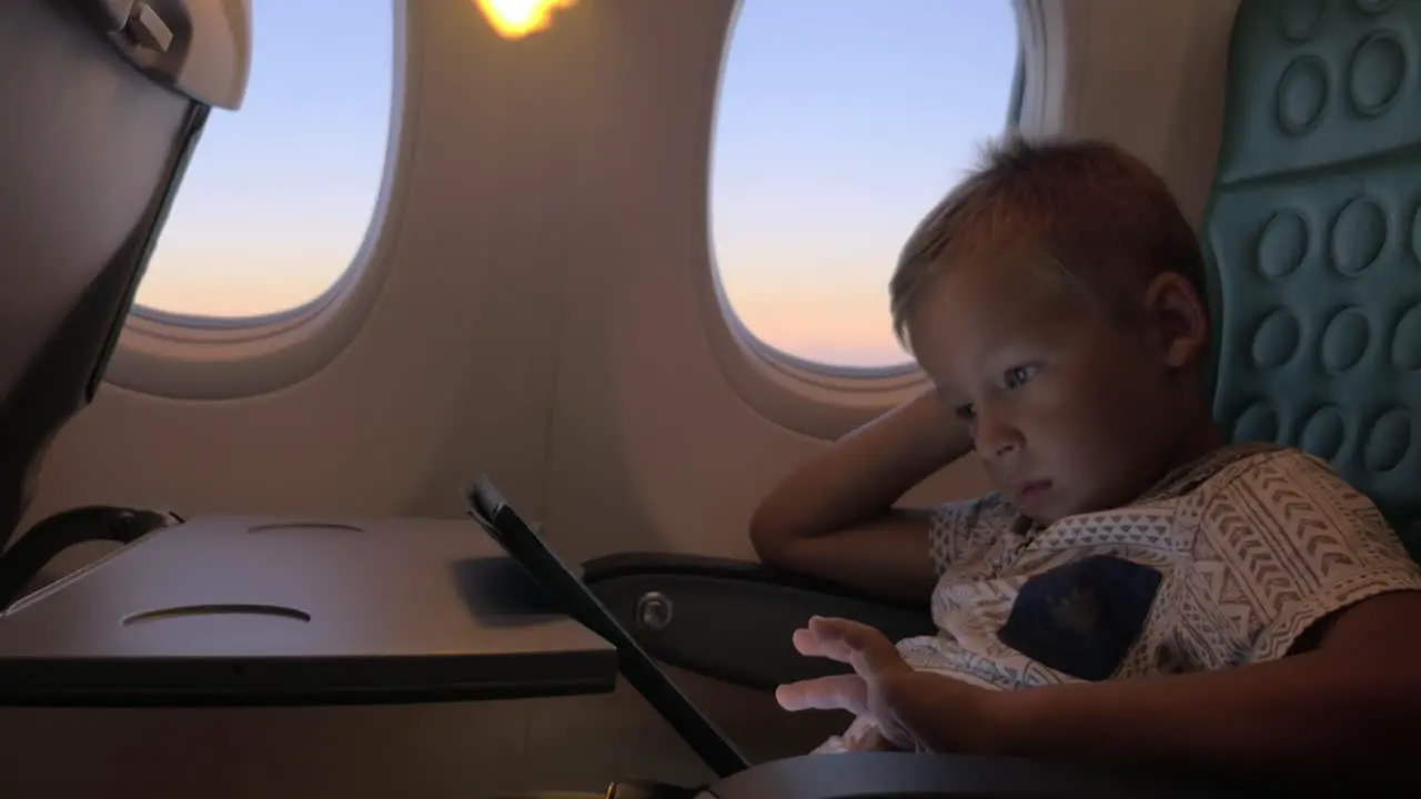 Bored kid with pad in plane