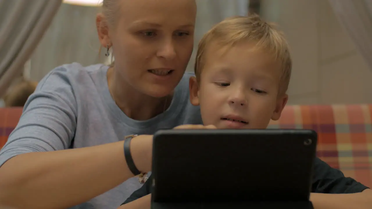 Child and mom with digital tablet in cafe