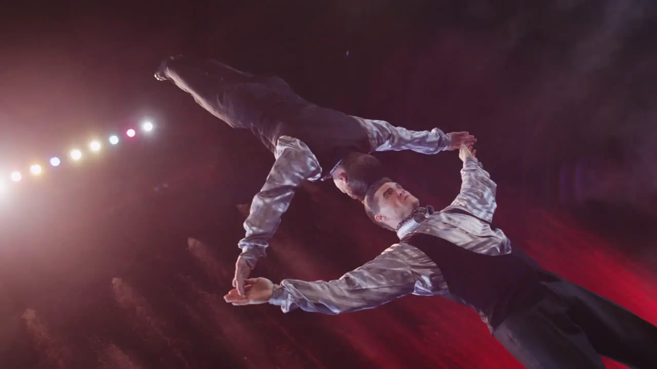 Close up view of acrobats making act with against colorful fountains Moscow Russia