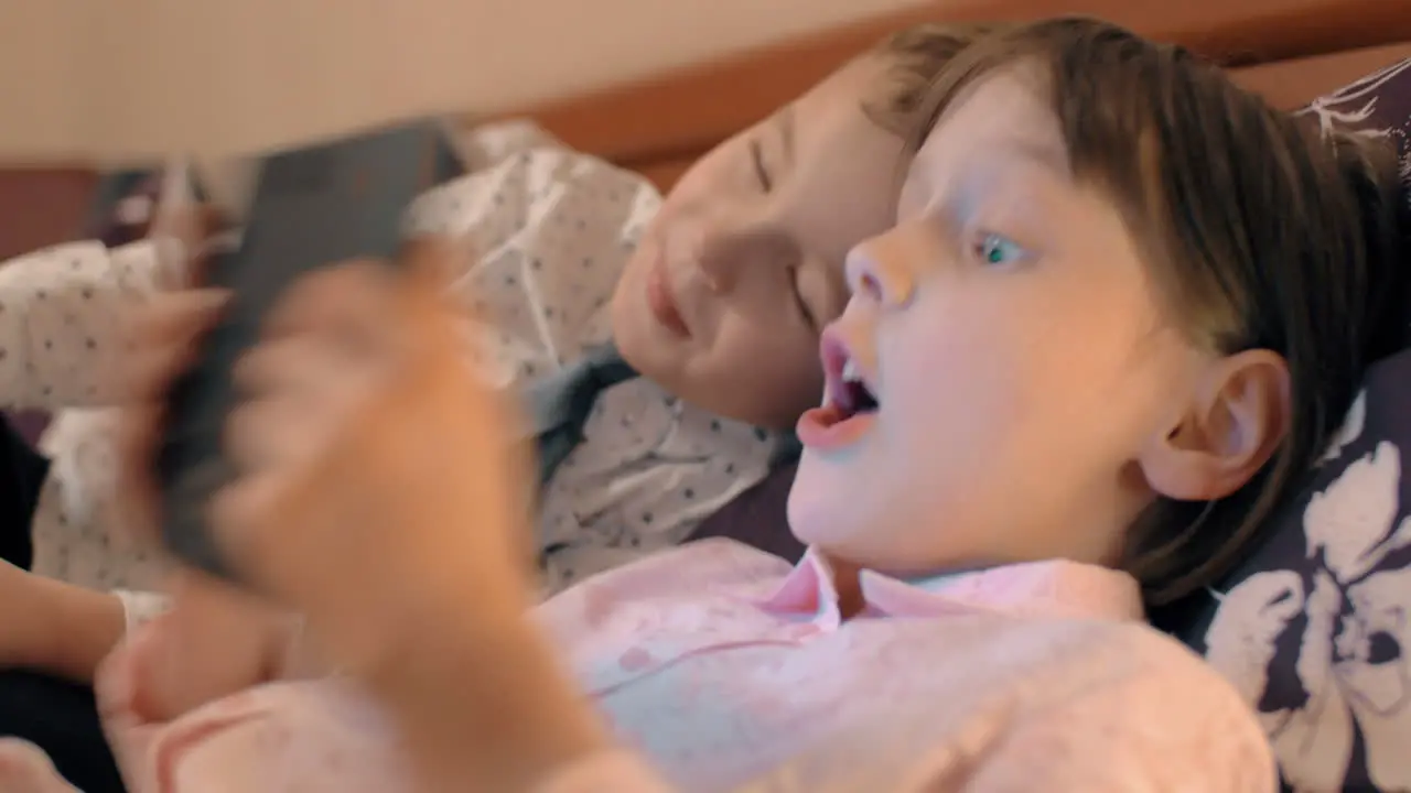 Boy and girl kissing each other and playing games on touch pad