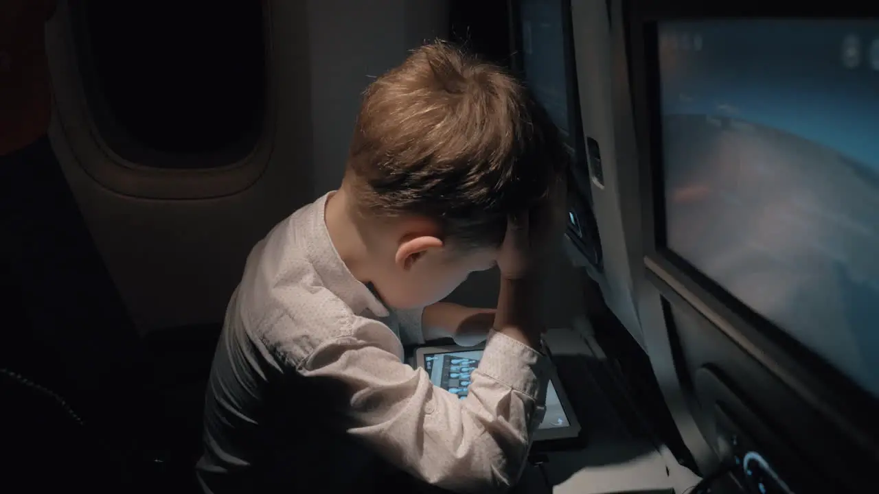 Kid playing pad chess game when traveling by plane at night