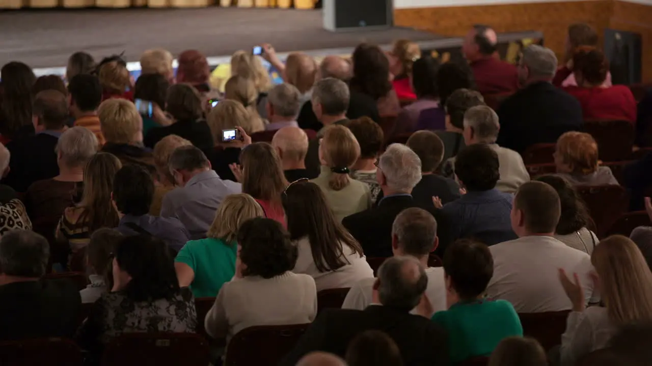 People seated in an audience and applauding