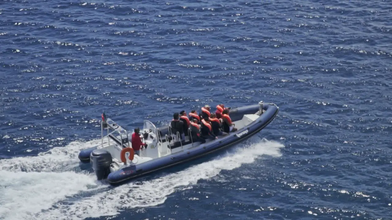 Super slow motion shot of boat filled with people traveling on the ocean