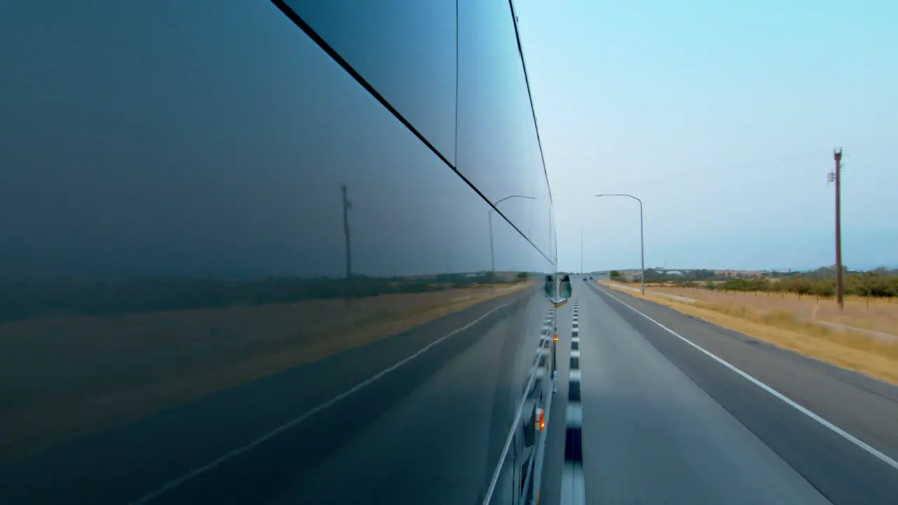 Side view of a public bus shuttle or school bus driving and the road reflection on it