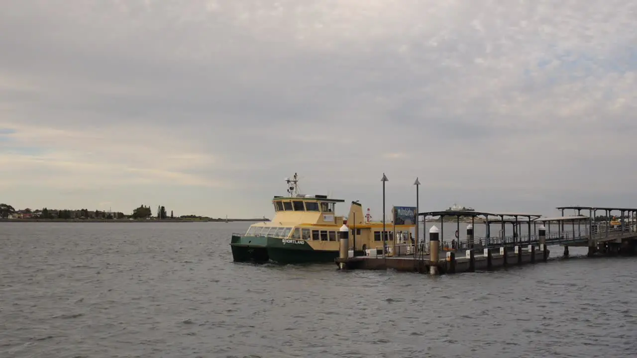 Ferry leaving berth on Newcastle harbour at dusk