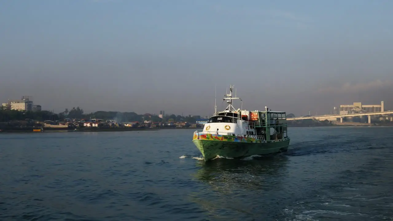 Small ferry passes the Marcelo Fernan Bridge connecting Mactan and Cebu islands as it traverses the Mactan Channel Philippines