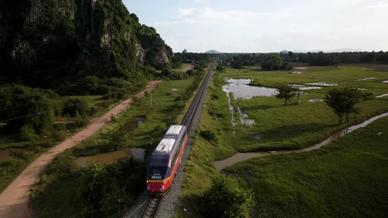 Passenger train traveling through scenic Cambodia countryside