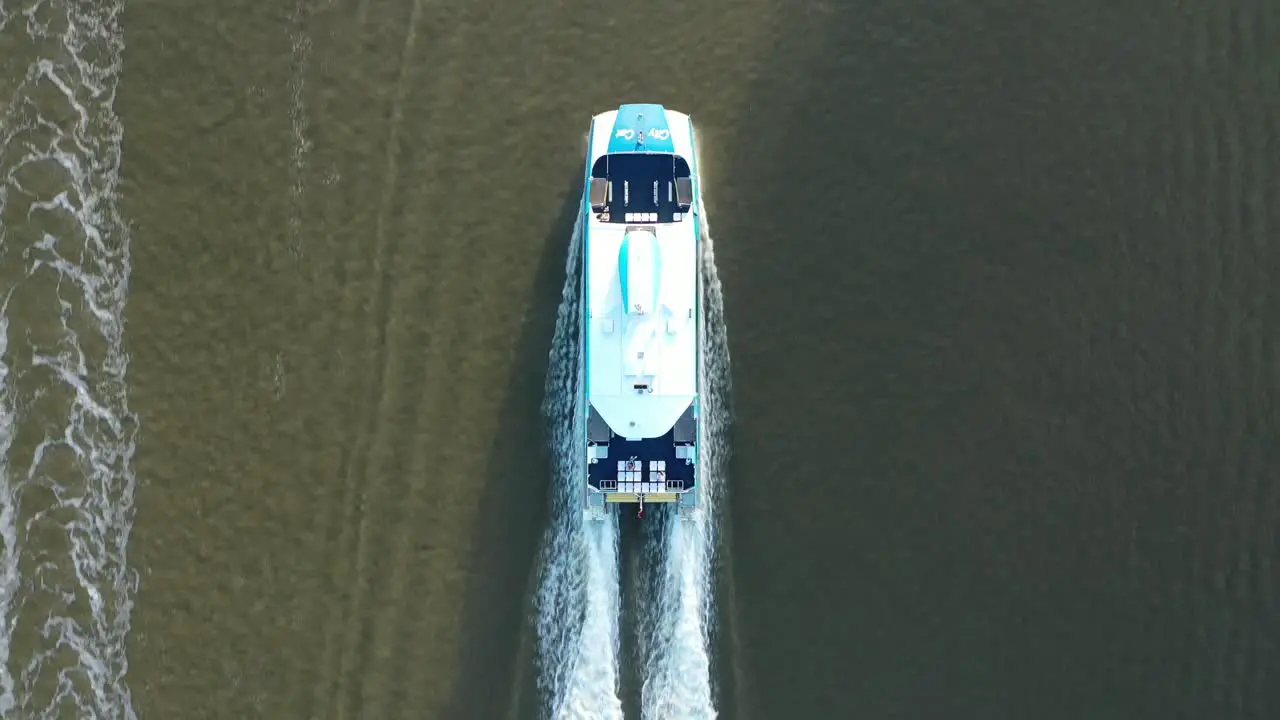 Top down drone shot tracking City Cat Boat driving along Brisbane River