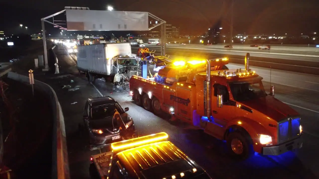 Aerial establishing shot of Crash scene long truck accident Tow truck with emergency lights on