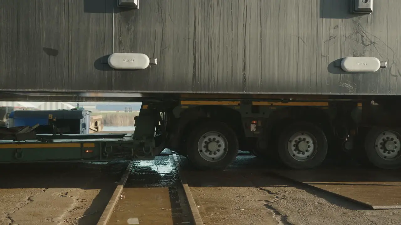 Truck with heavy cargo slowly rolling across tracks close up