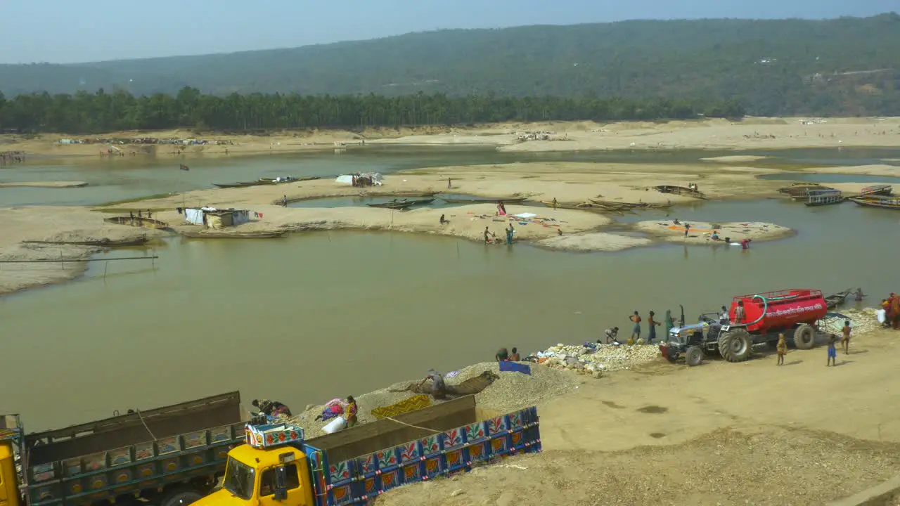 Panning shot of daily life in Jaflong alongside the Piyain River in Bangladesh