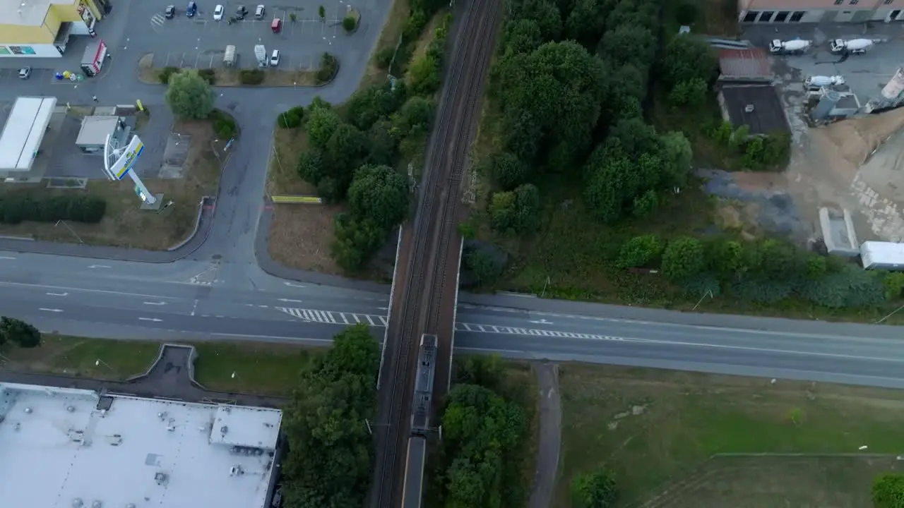 Bird's eye view of a train passing over a bridge in an urban urban environment