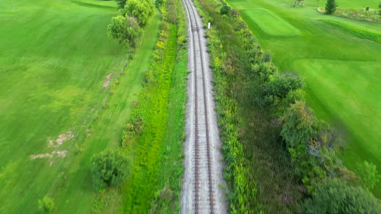 Drone flying above empty train track in countryside and nature