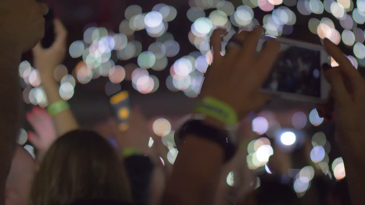 Audience waving with cellphone flashlights at the concert