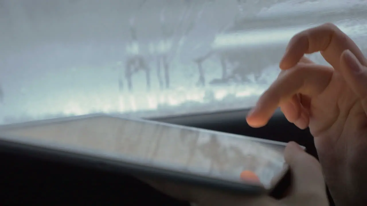 Woman typing on tablet computer in the car