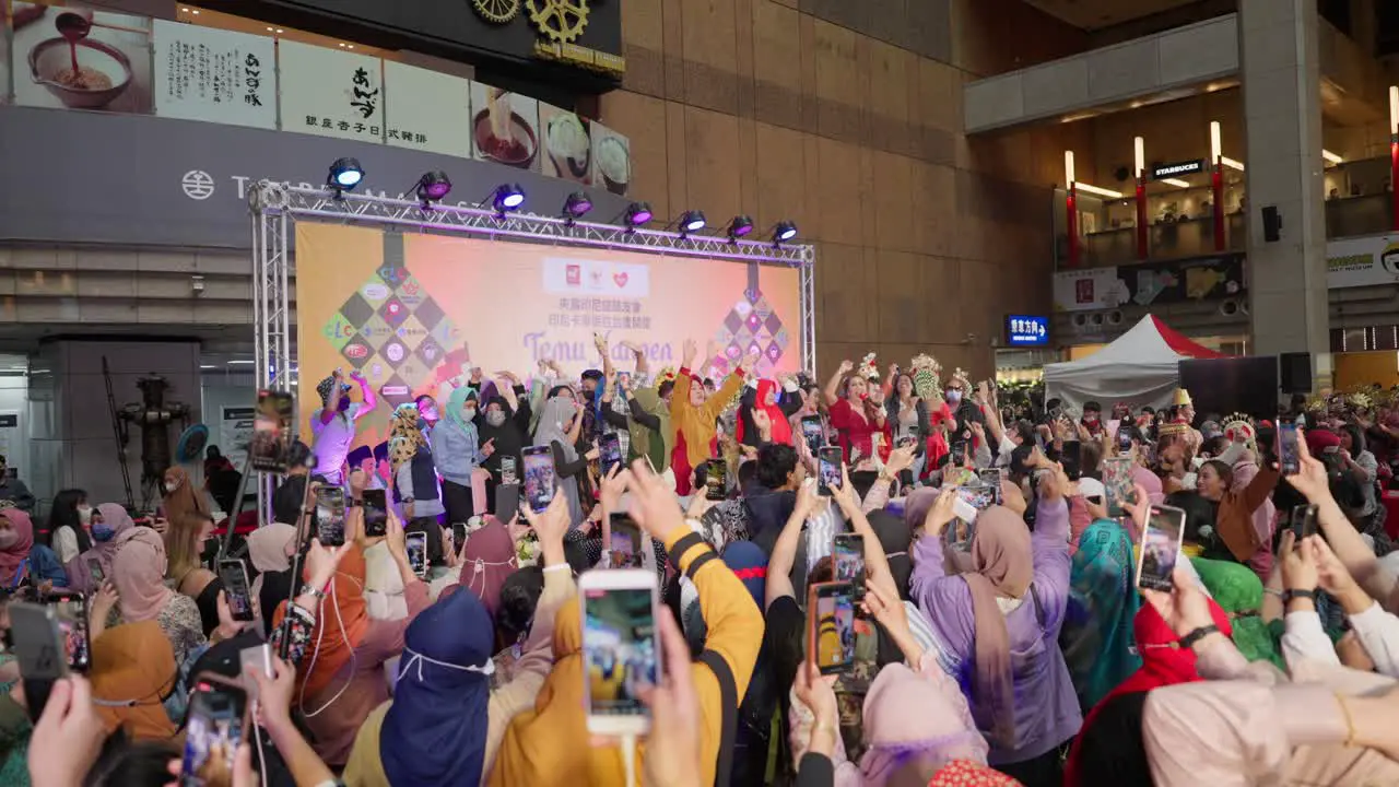 Crowds of Indonesian Migrant Workers Singing Jumping and Dancing both on and off stage