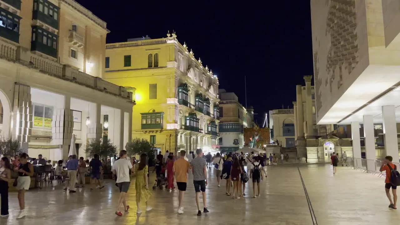 Plaza at the entrance gate in Valletta full of people at night