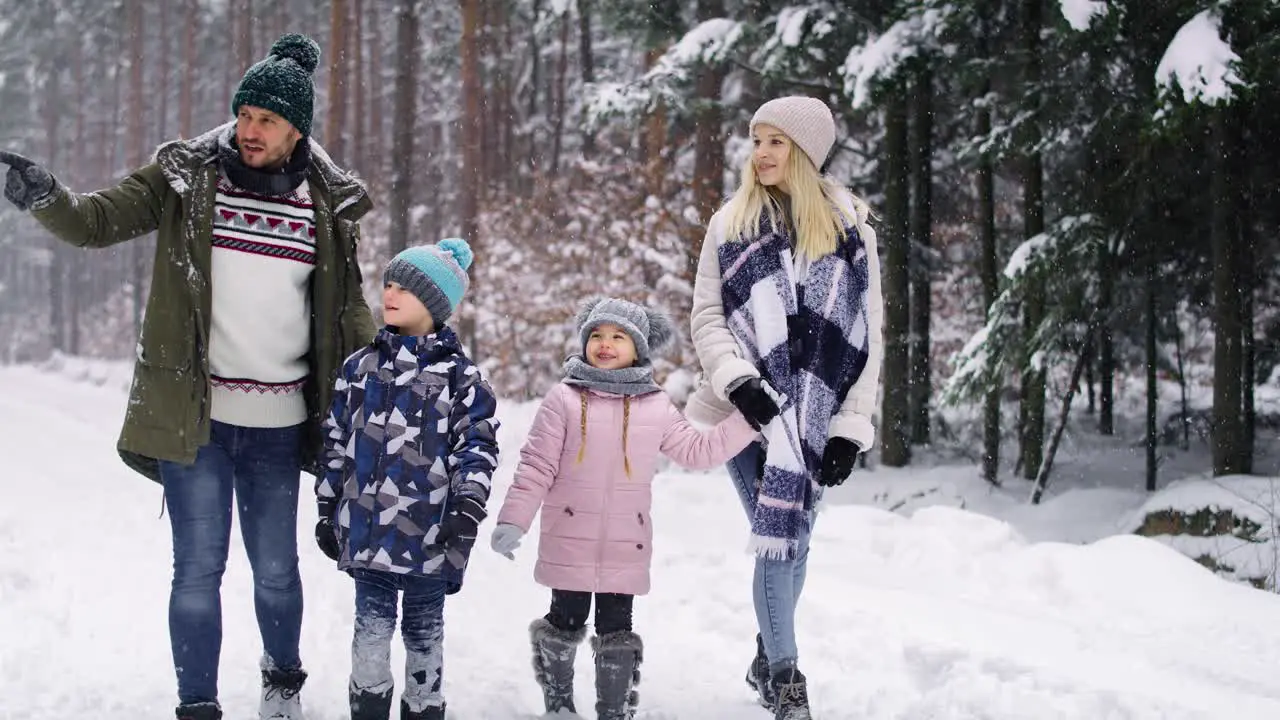 Handheld video of family walking in the winter forest