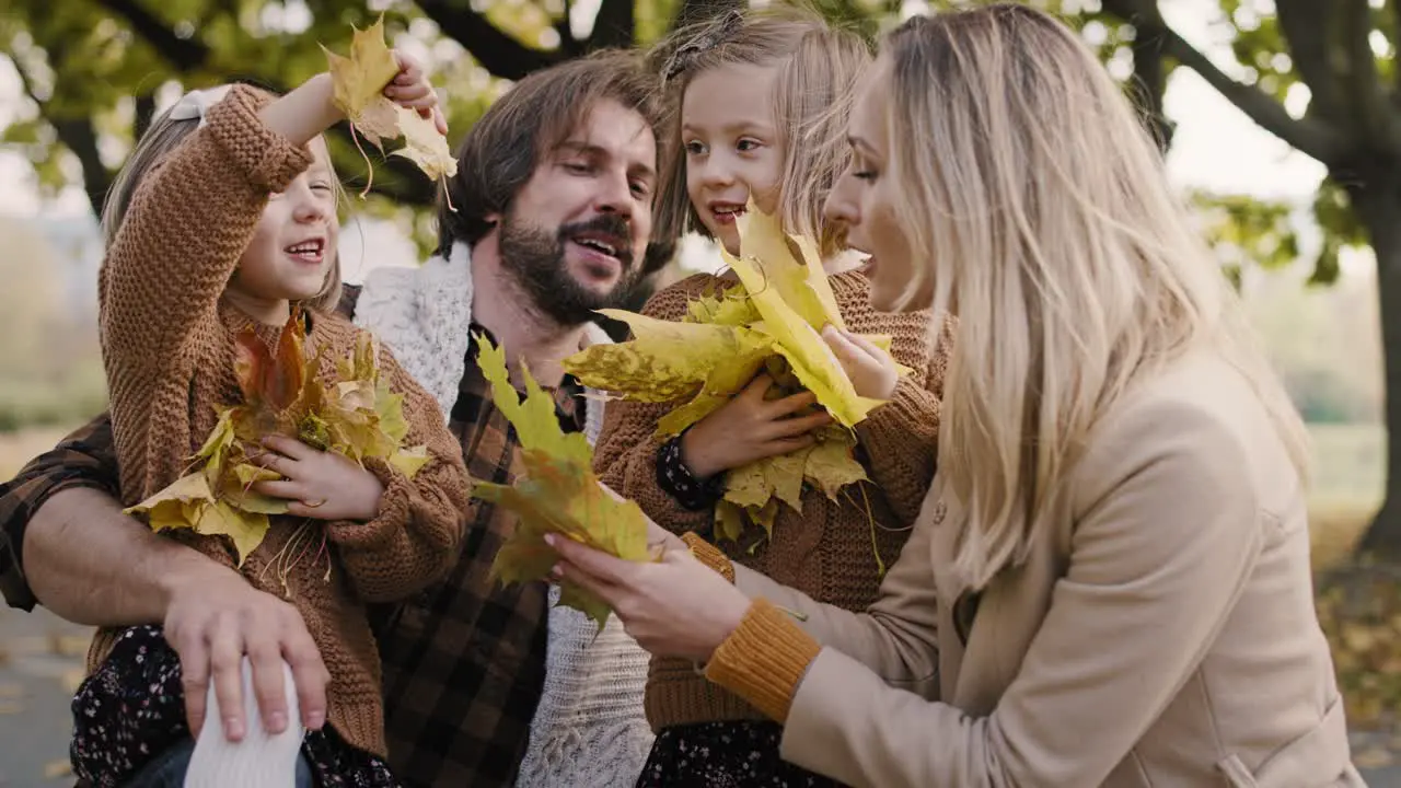 Happy family picking leafs on the fall season