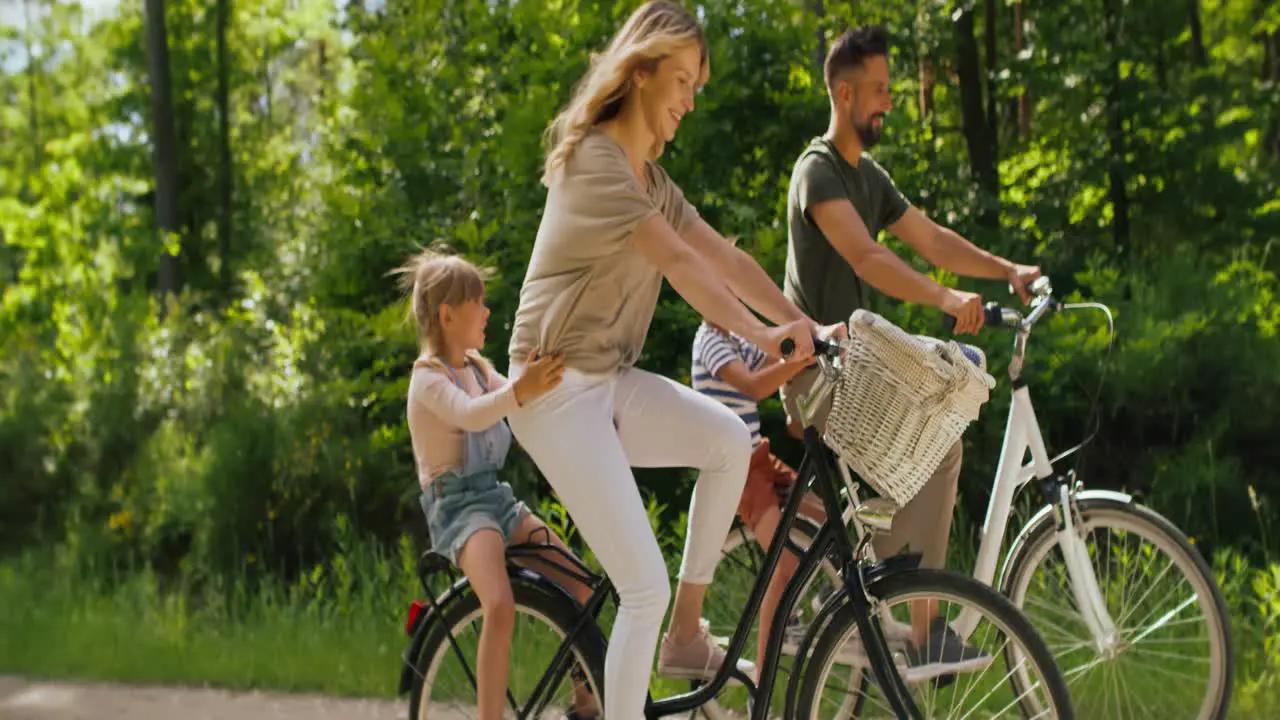 Video of playful family having fun on a bicycles in the woods