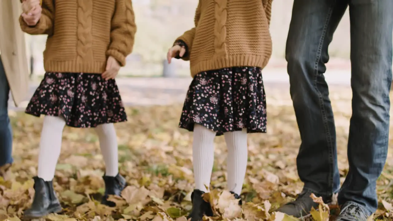 Tilt up video shows of family walking in autumn forest