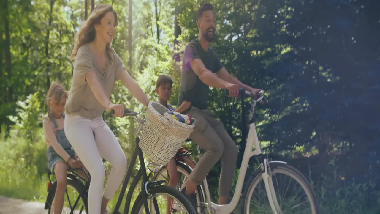 Video of playful family riding bikes in the woods