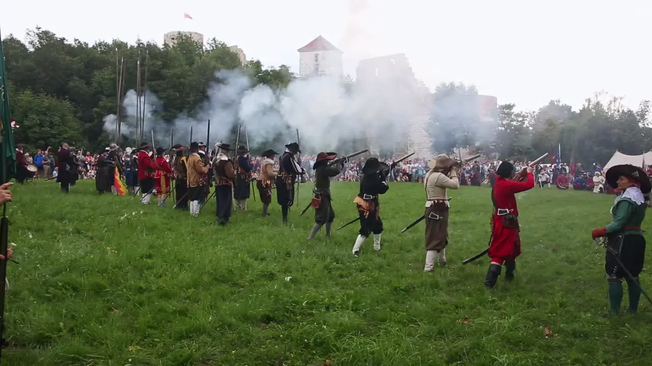 Group of infantry soldiers firing muskets during battle reenactment in Tenczyn Castle Poland