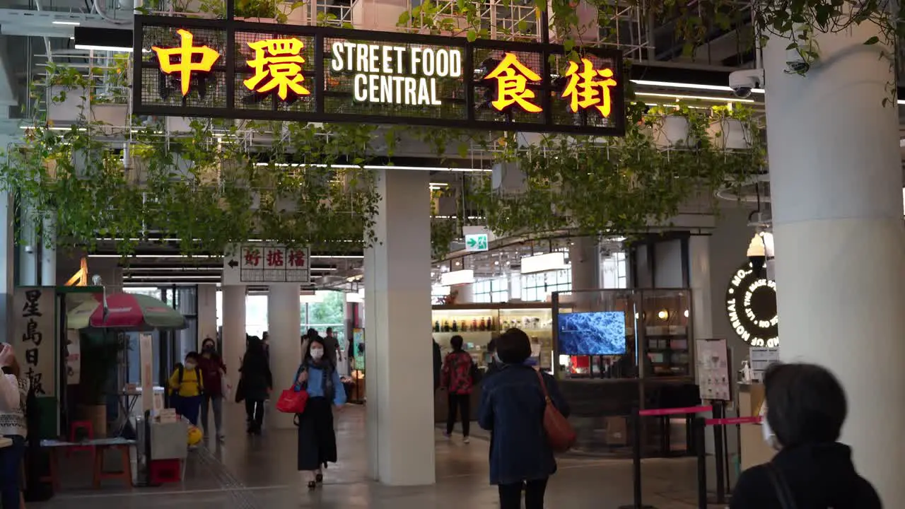 People Walking Through Past Vendors At Street Food Central Indoor Market In Hong Kong