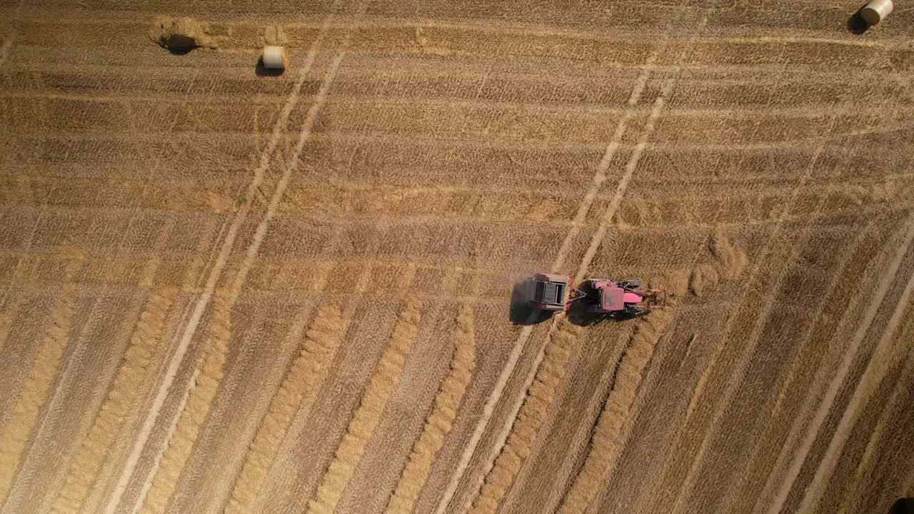 Aerial view of tractor harvesting on agricultural land for food production