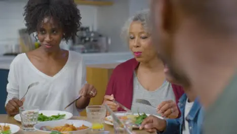 Family Around Table Eating an Evening Meal Together