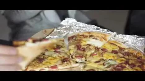 Close-up Of People Hands Taking Slices Pizza from food delivery open box Tasty Service to office Focus changes from hands and goes up to show business people in the office Shot in 4k