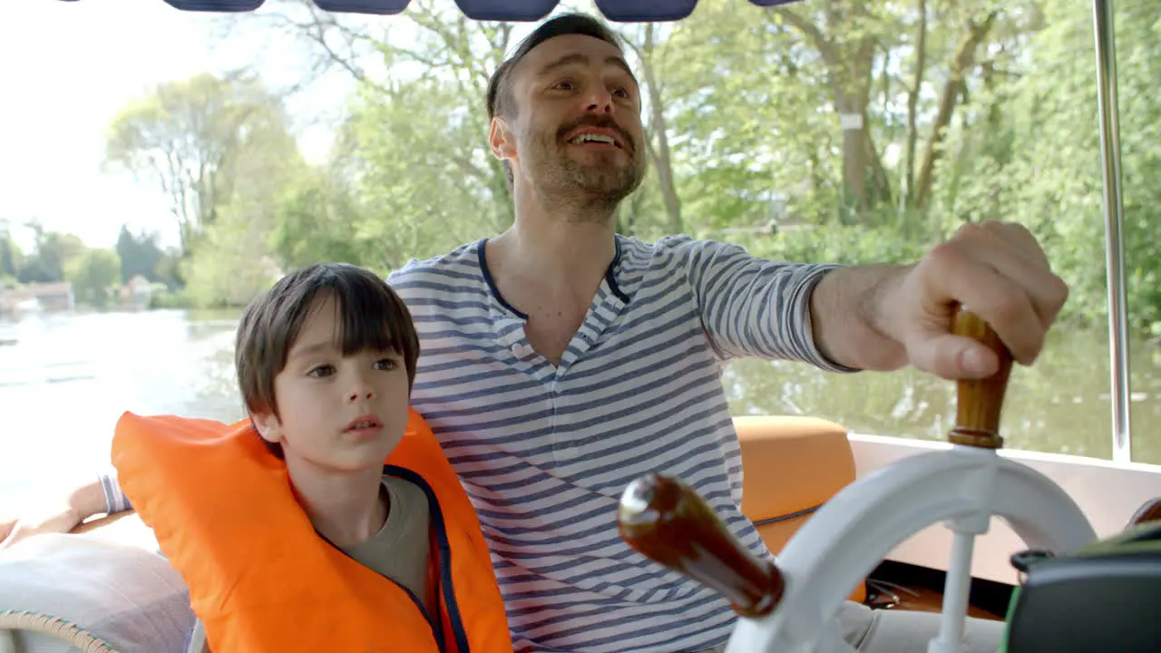 Father And Son Enjoy Ride In River Boat Shot In Slow Motion