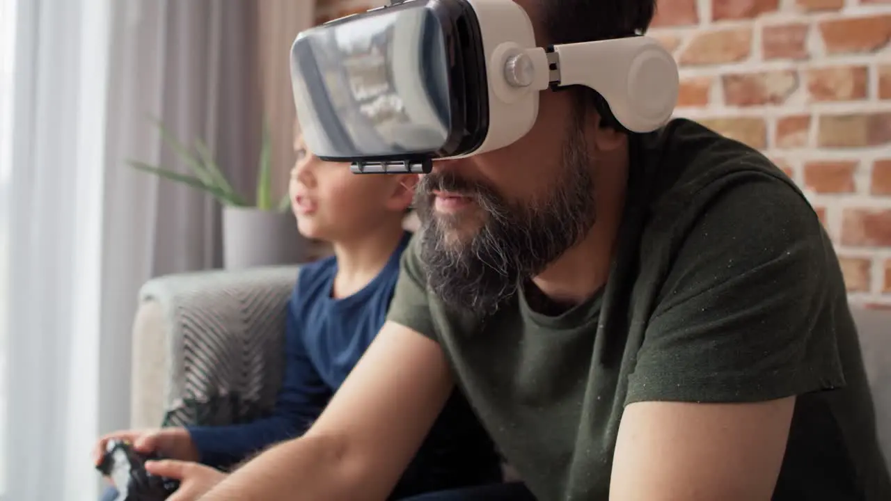 Video of father wearing VR glasses playing with son at home