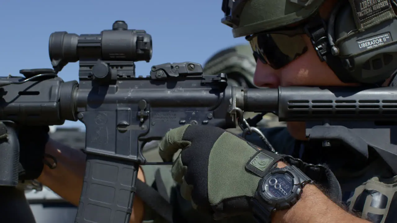 Soldiers fire their scoped rifles in a line