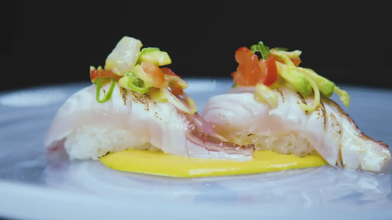 Palatable nigiri sushi garnished by fresh fruits with sauce on plate