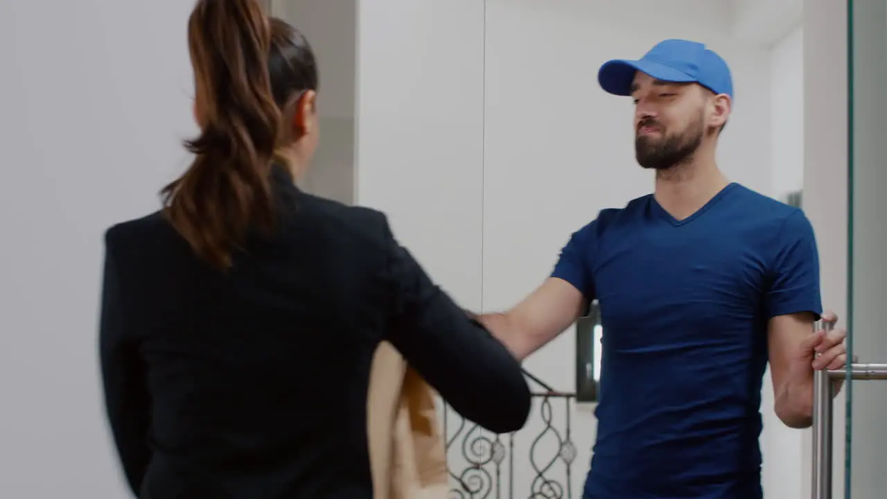 Delivery man giving takeaway delivery food order package to businesswoman during lunchtime