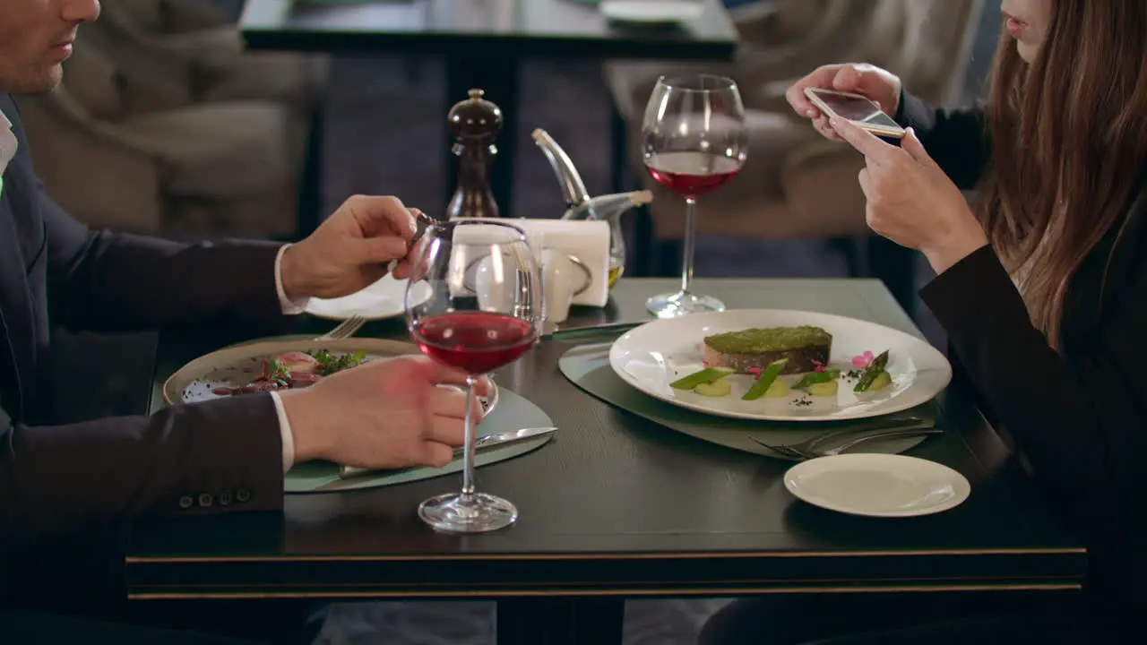 Business woman photographing food on smartphone at restaurant