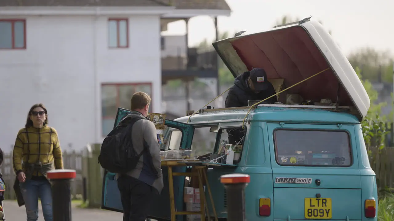 Vintage street food van with open roof while person buying snack