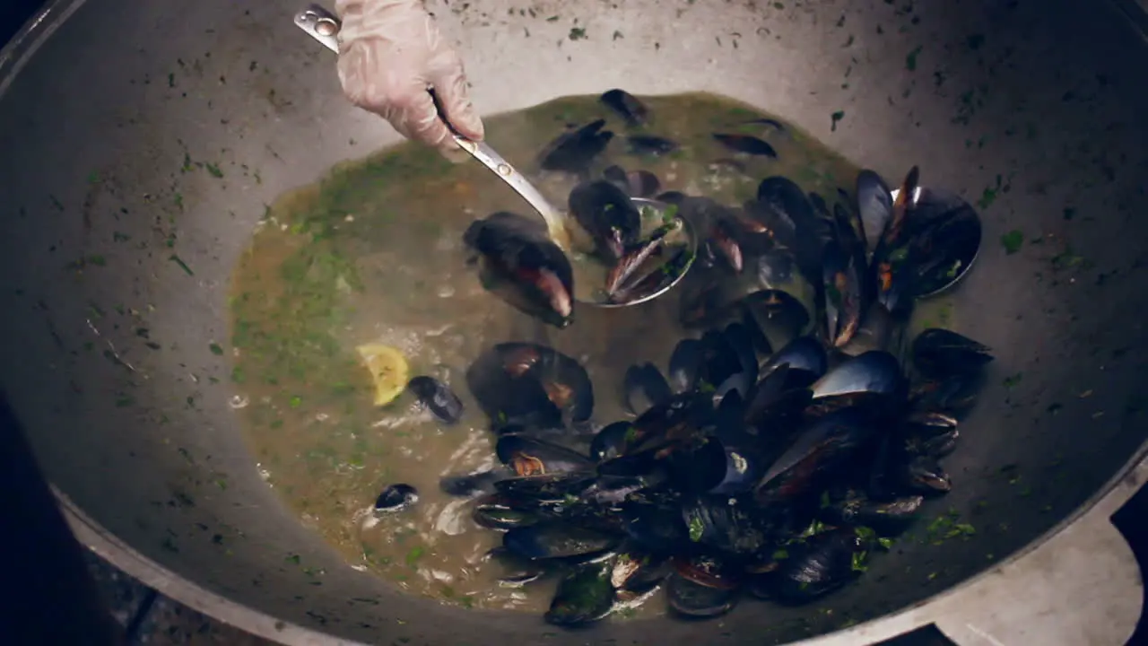 Cooking mussels on pan Mussel shells cooked in pan at street food festival