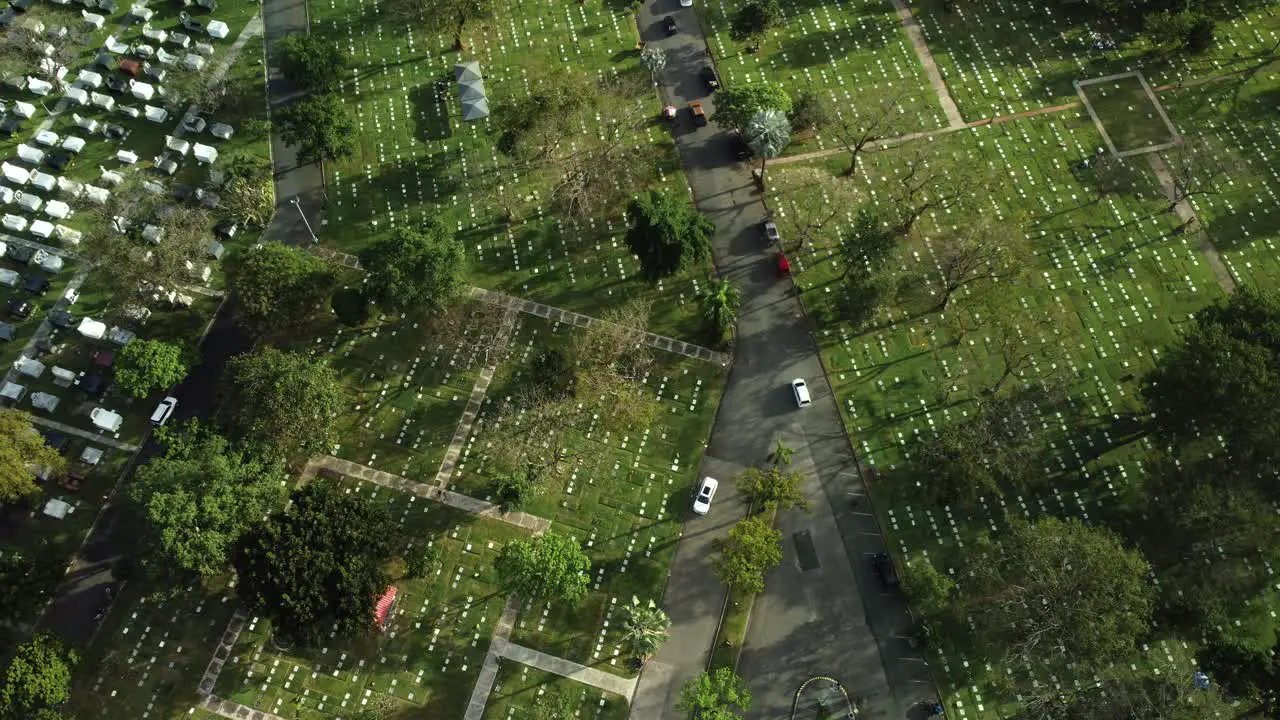 Drone shot of cars driving in cemetery