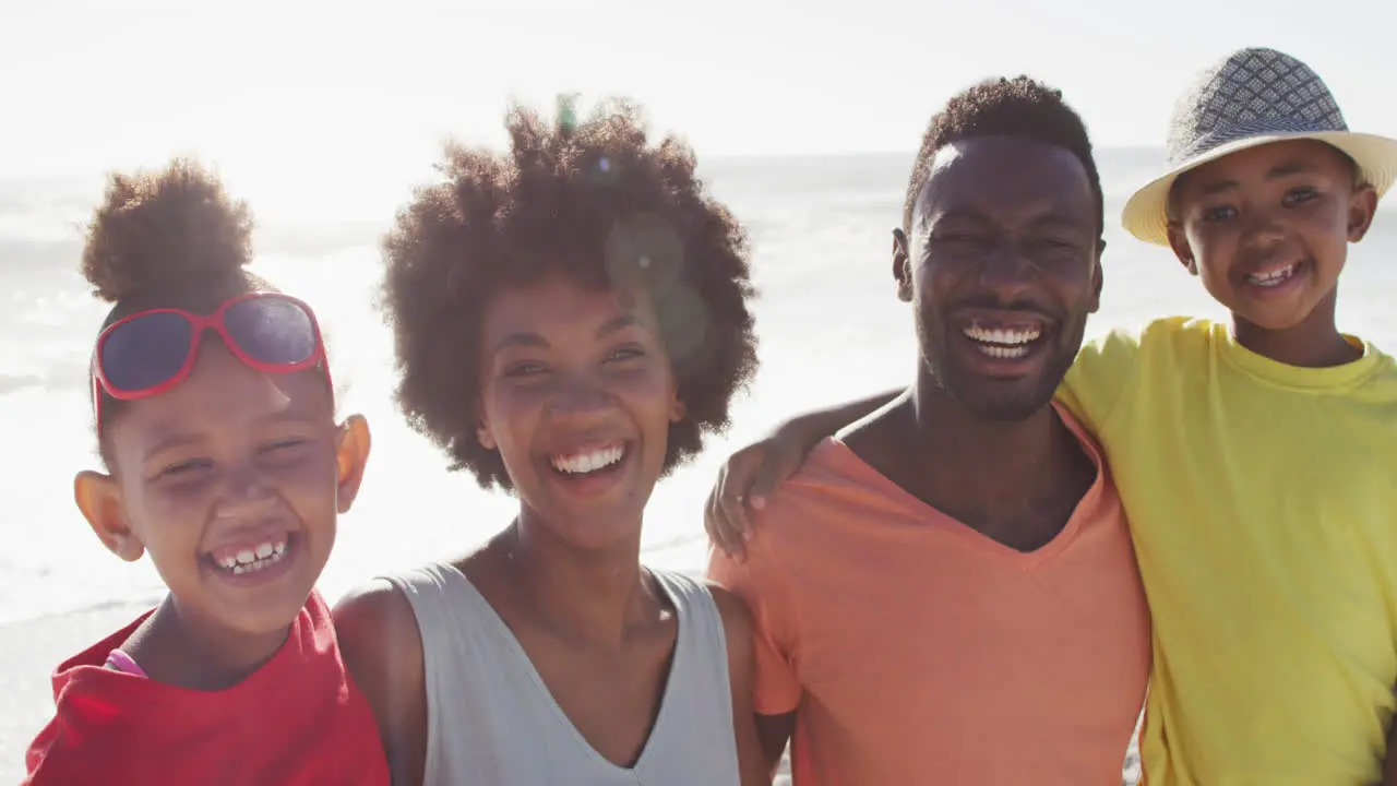 Portrait of smiling african american family embracing on sunny beach