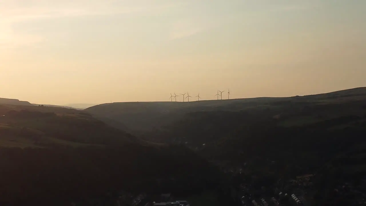 Wind turbine eco farm in the distance on beautiful golden hour evening mountain landscape