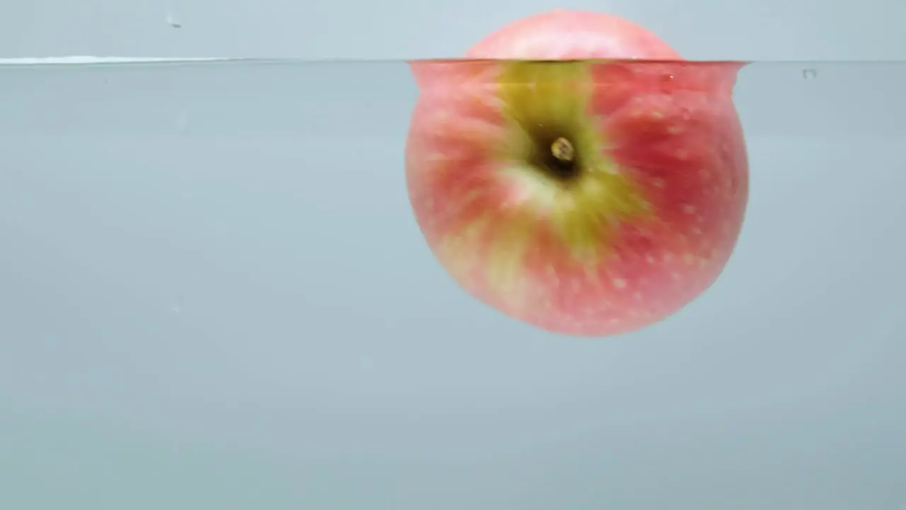 Red and Green Apple Spinning In Water