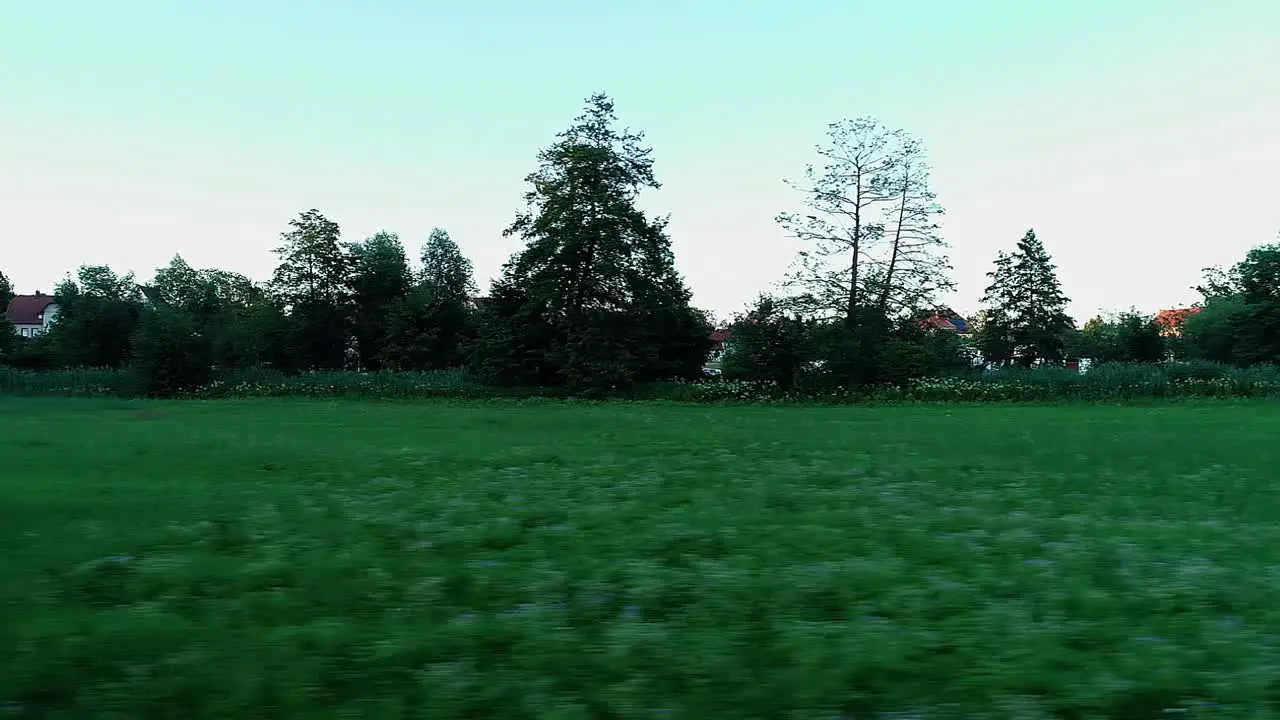 a drone flies sideways close to the ground over the grass on a green meadow