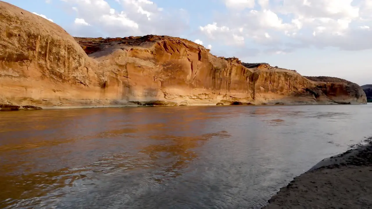 Pan of canyon wall from river banks in Utah